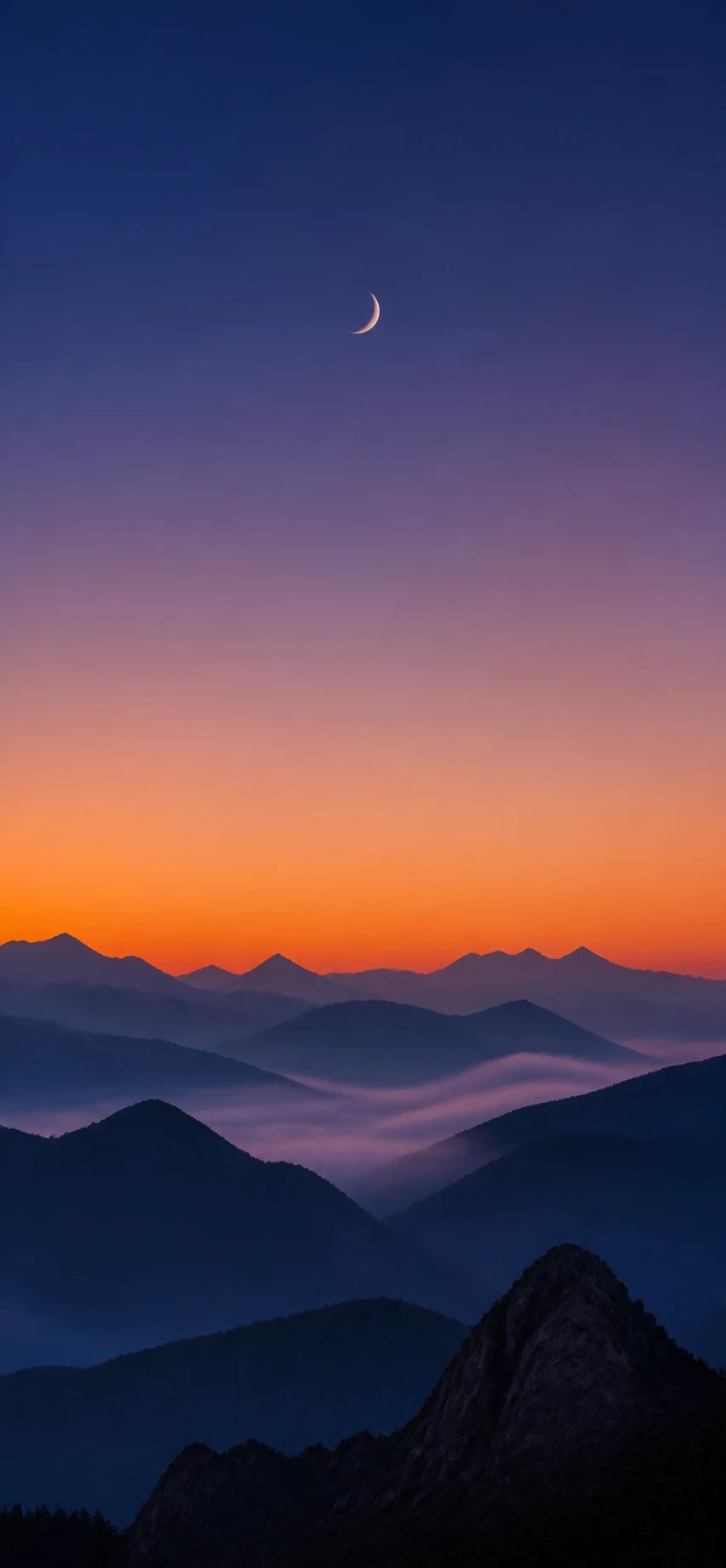 Phone wallpaper — misty layered mountains at dusk under an indigo-to-amber gradient sky with a crescent moon