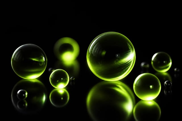 A cluster of glossy glass spheres lit in green